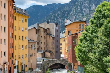 ESCALDES-ENGORDANY, ANDORRA - 2020 Juny 8: Engordany Köprüsü 'ndeki Valira Nehri ve Andorra' daki küçük Escaldes-Engordany kasabasında kar yağışlı bir günde evler.