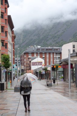 Escaldes - Engordany, Andorra: 16 Haziran 2020: Andorra 'nın başkentinde bulutlu ve yağmurlu bir gün. Şemsiyeli insanlar kendilerini Andorra la Vella, Andorra 'daki yağmurdan koruyorlar..