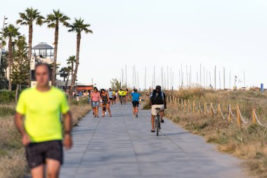 Castelldefels, İspanya: 25 Haziran 2020: COVID 19 Haziran 2020 'den sonra yaz mevsiminde Barselona' da insanlar Castelldefels kıyılarında yürür.