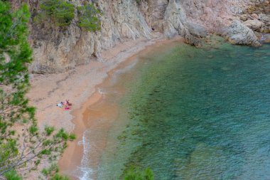 Güzel Cala Futadera plajında toplanan aile, Costa Brava, Katalonya, İspanya 'da bozulmamış kalan az sayıdaki doğal plajdan biridir..