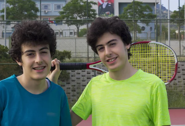 stock image Happy young twin on the tennis court