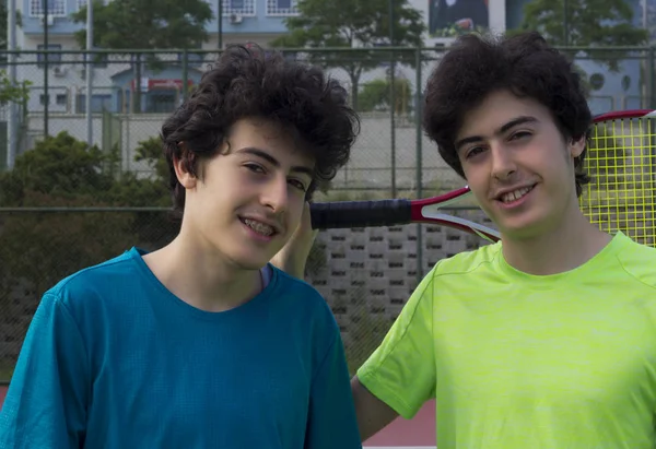 テニスコートで幸せな若い双子 — ストック写真