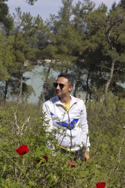 Adam doğada kameraya bakıyor.