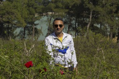 Adam doğada kameraya bakıyor.