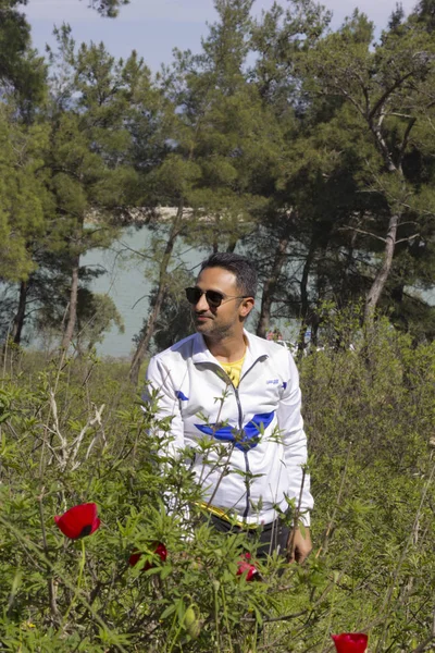 Adam doğada kameraya bakıyor.