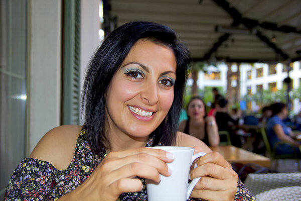 Красивая молодая женщина пьет кофе
