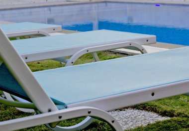 Dinlenme sandalyeli bir tatil köyünde yüzme havuzu.
