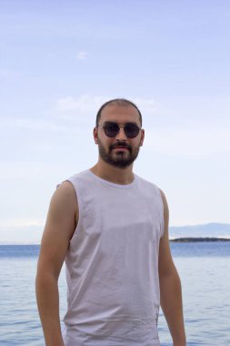  Sahilde güneş gözlüklü genç adam.