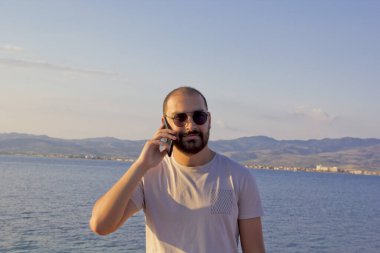 Kumsalda telefondaki genç adam.