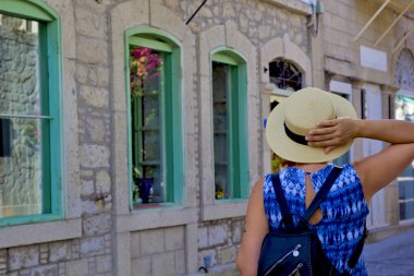 Genç kadın Alacati 'nin dar sokaklarında yürüyor, Cesme Turkey