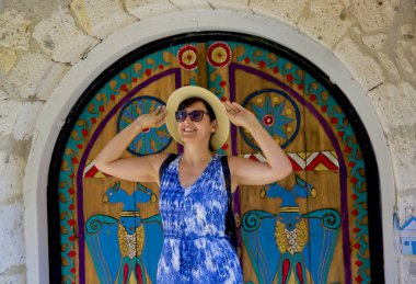 Genç kadın Alacati 'nin dar sokaklarında yürüyor, Cesme Turkey