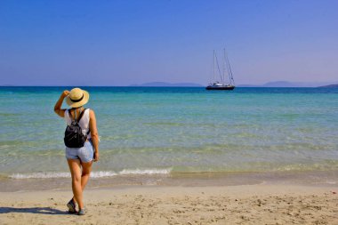 Kumsalda şapkalı güzel bir kadın.