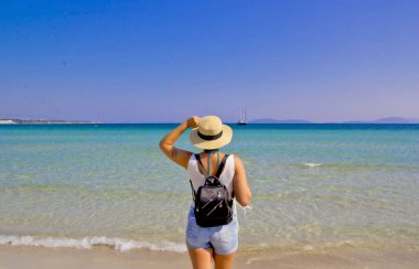 Kumsalda şapkalı güzel bir kadın.