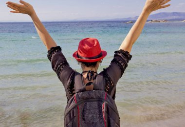 Kumsalda kırmızı şapkalı güzel bir kadın.