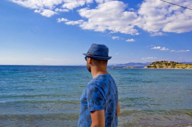 Kumsalda mavi şapkalı genç adam