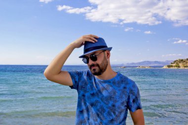 Kumsalda mavi şapkalı genç adam