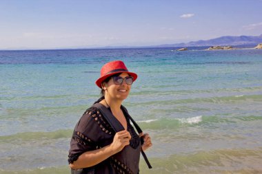 Kumsalda kırmızı şapkalı güzel bir kadın.