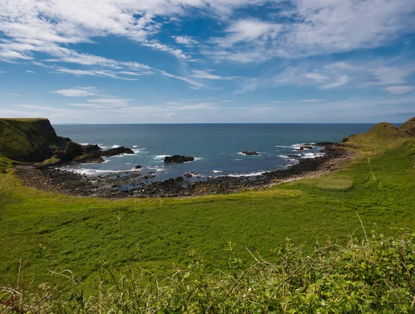 Causeway Sahil ön planda yeşil alanı olan siyah taşlarla küçük koy