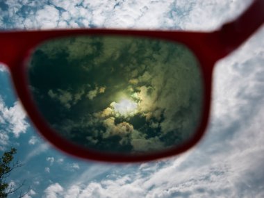 Direct view of the sun through red sunglasses with UV protection clipart
