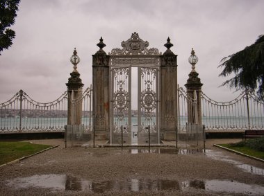 Dolmabahce Sarayı 'ndan Dolmabahce Körfezi' nde yüksek kolonları ve kapısı olan bir çit.
