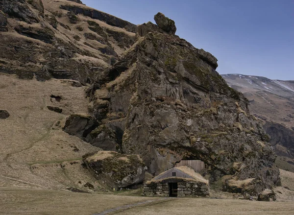 Litet hus framför Rutshellir Cave — Stockfoto