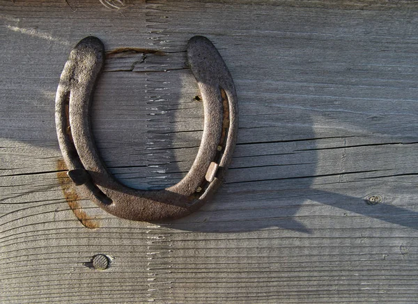 A horseshoe on a wooden board as a lucky charm — Stock Photo, Image