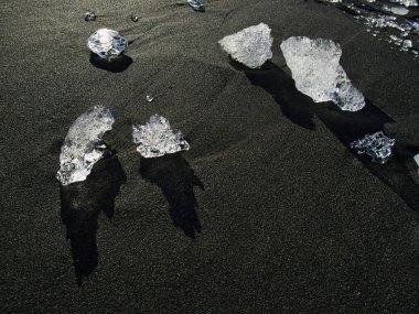 Siyah kumdaki buzuldan küçük buz parçaları