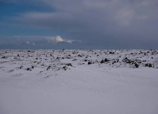 Schneebedecktes Feld in Island mit Lavasteinen — Stockfoto