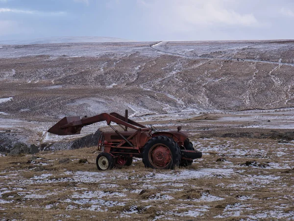 En gammal traktor med frontlastare på en äng — Stockfoto