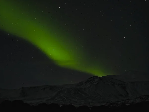 Ένα πράσινο βόρειο φως πάνω από ένα βουνό στην Ισλανδία — Φωτογραφία Αρχείου