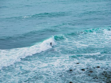 Kaliforniya kıyısında sörf tahtasında bir adam