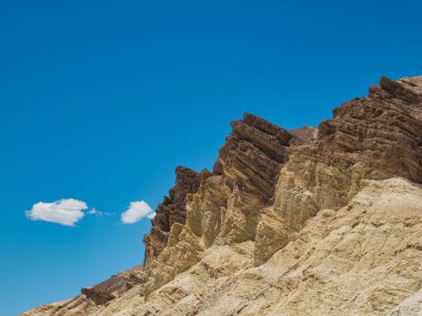 Farklı renkleri ve şekilleri olan çıplak bir kaya dağı.