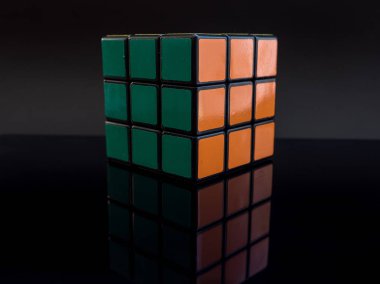Stüdyo ışık yansıması ile siyah arka plan üzerinde Rubik küpü çözüldü