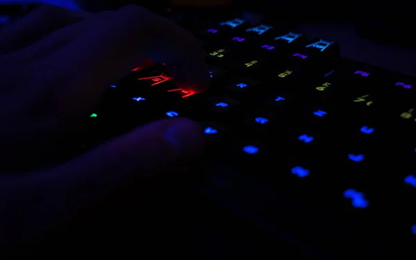 游戏键盘与 Rgb 照明的家伙有他的手在游戏位置焦点 — 图库照片