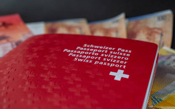 swiss passport and money close up on black background switzerland citizenship and currency