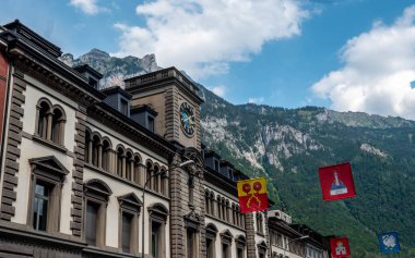 Glarus, İsviçre. Saat ve swiss Kanton bayraklar dağ toplayan infront ile eski bina