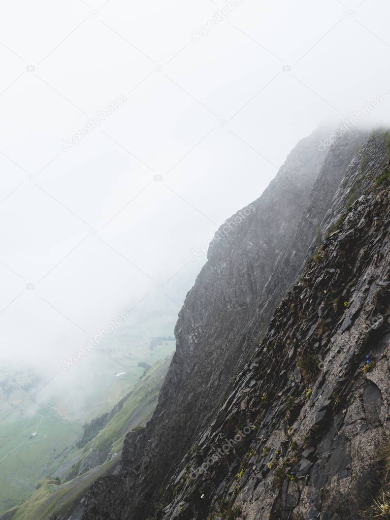 scary steep mountain scenery covered in fog in the swiss alps brienzer rothorn switzerland