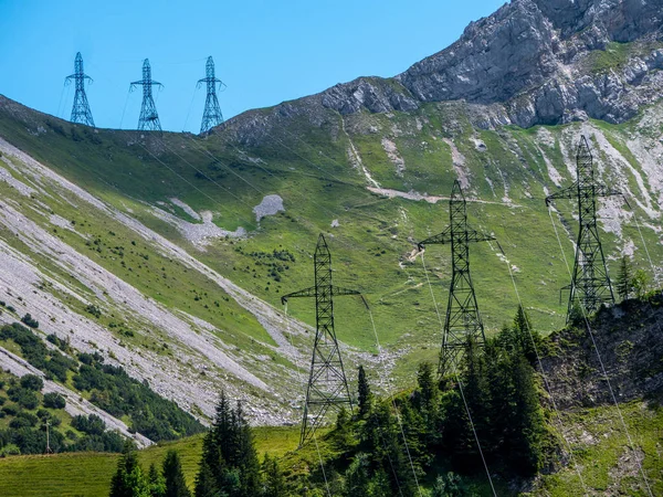 three high voltage post power poles in the mountains steep high voltage tower switzerland alps sunny