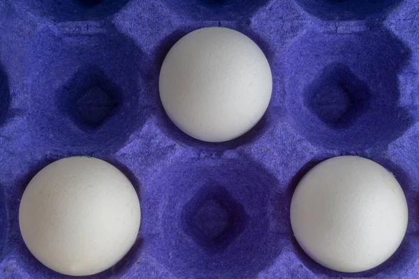 White eggs closeup in egg tray with selective focus and crop fragment