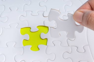 Parçalı bulmaca closeup görevi tamamlamak için son parçası elini. Seçici odak ve kırpma parçası