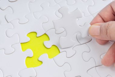 Parçalı bulmaca closeup görevi tamamlamak için son parçası elini. Seçici odak ve kırpma parçası