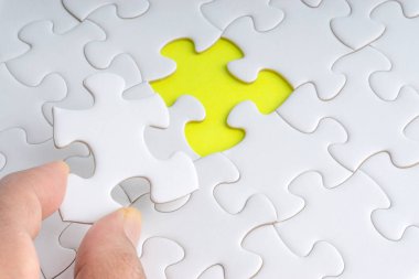 Parçalı bulmaca closeup görevi tamamlamak için son parçası elini. Seçici odak ve kırpma parçası