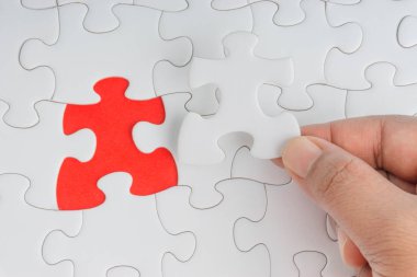 Parçalı bulmaca closeup görevi tamamlamak için son parçası elini. Seçici odak ve kırpma parçası