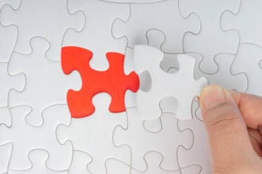 Parçalı bulmaca closeup görevi tamamlamak için son parçası elini. Seçici odak ve kırpma parçası