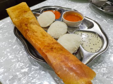 Masala Dosa ve Idli Dosa gıda closeup seçici odak ve kırpma parçası ile. Bu popüler Güney Hint tüm zaman besindir
