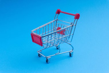 Alışveriş sepeti mavi arka plan, iş ve alışveriş kavramı. Seçici odak