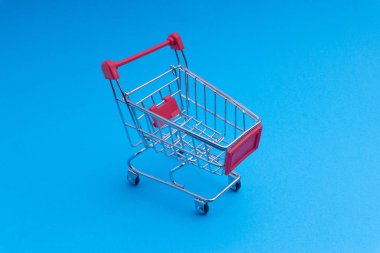 Alışveriş sepeti mavi arka plan, iş ve alışveriş kavramı. Seçici odak