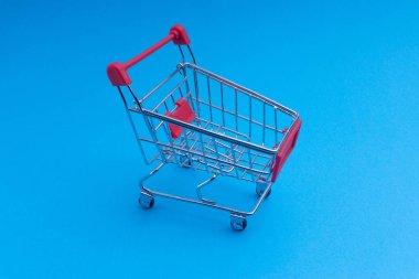 Alışveriş sepeti mavi arka plan, iş ve alışveriş kavramı. Seçici odak