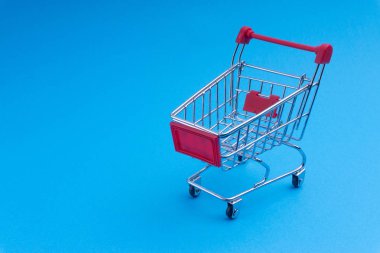 Alışveriş sepeti mavi arka plan, iş ve alışveriş kavramı. Seçici odak