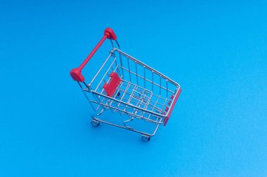 Alışveriş sepeti mavi arka plan, iş ve alışveriş kavramı. Seçici odak